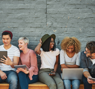 Diverse group of younger adults smiling and conversing.